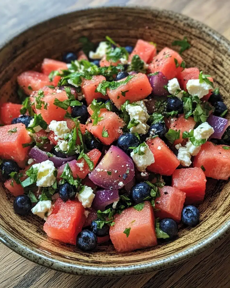 Light watermelon feta salad topped with fresh blueberries on a white plate